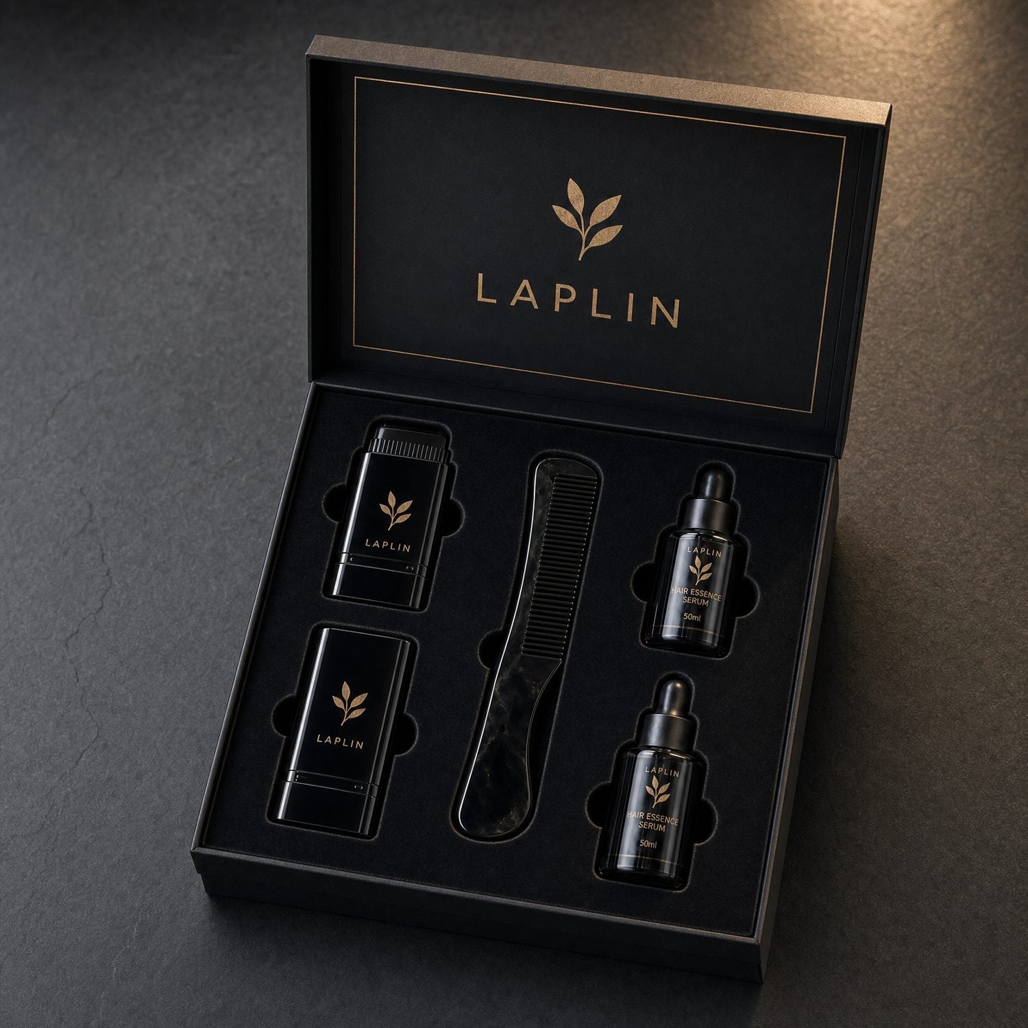The LAPLIN box open, showing two color-comb sticks, an obsidian comb and two essence serums in a velvet insert.